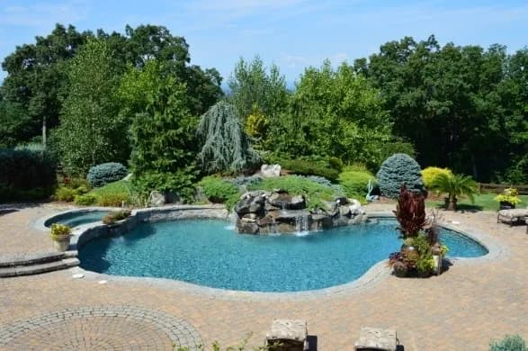 Pool with waterfall feature and pump-driven lighting